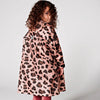 Child wearing a pink coat with a leopard print pattern on a white background