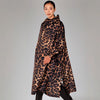 Woman wearing a leopard print coat on a plain background