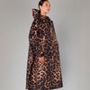 Person wearing a leopard print coat on a plain background